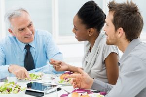 Business Colleagues Eating Meal Together While Discussing of Work